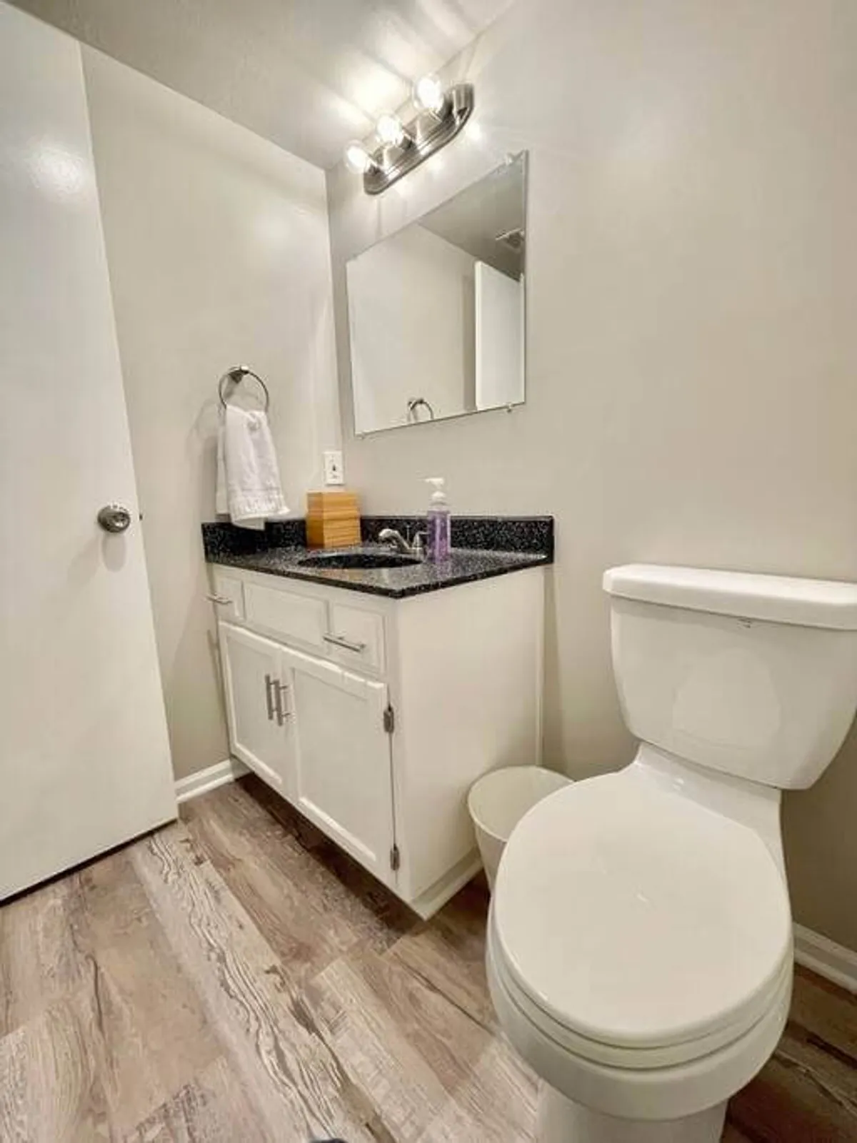 A functional half-bathroom with a sleek vanity, mirror, and toilet. The room is bright, clean, and designed for convenience—perfect for quick refreshes or as a guest bathroom downstairs.